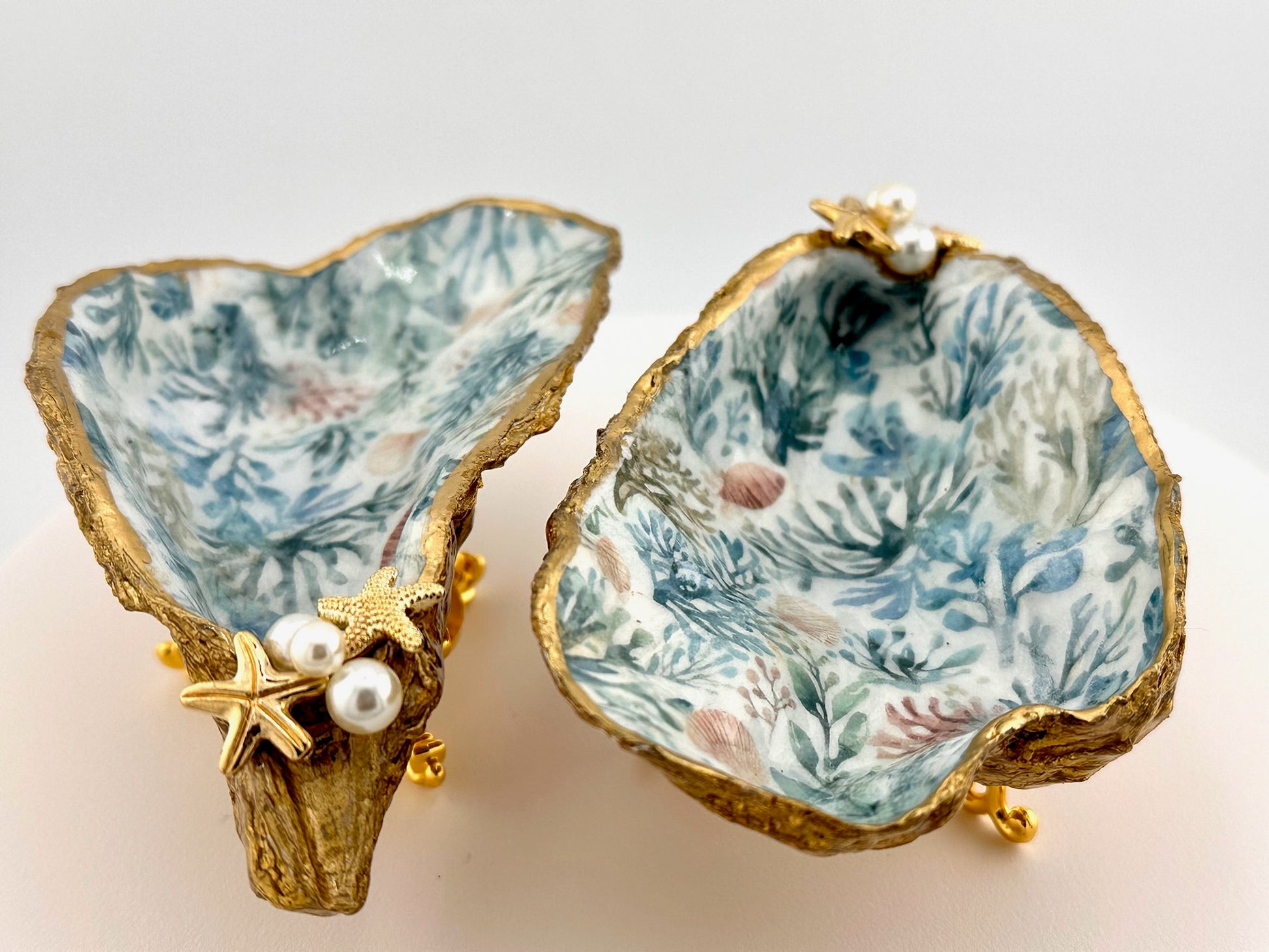 Decorative shell with coral pattern and gold accents on a light background