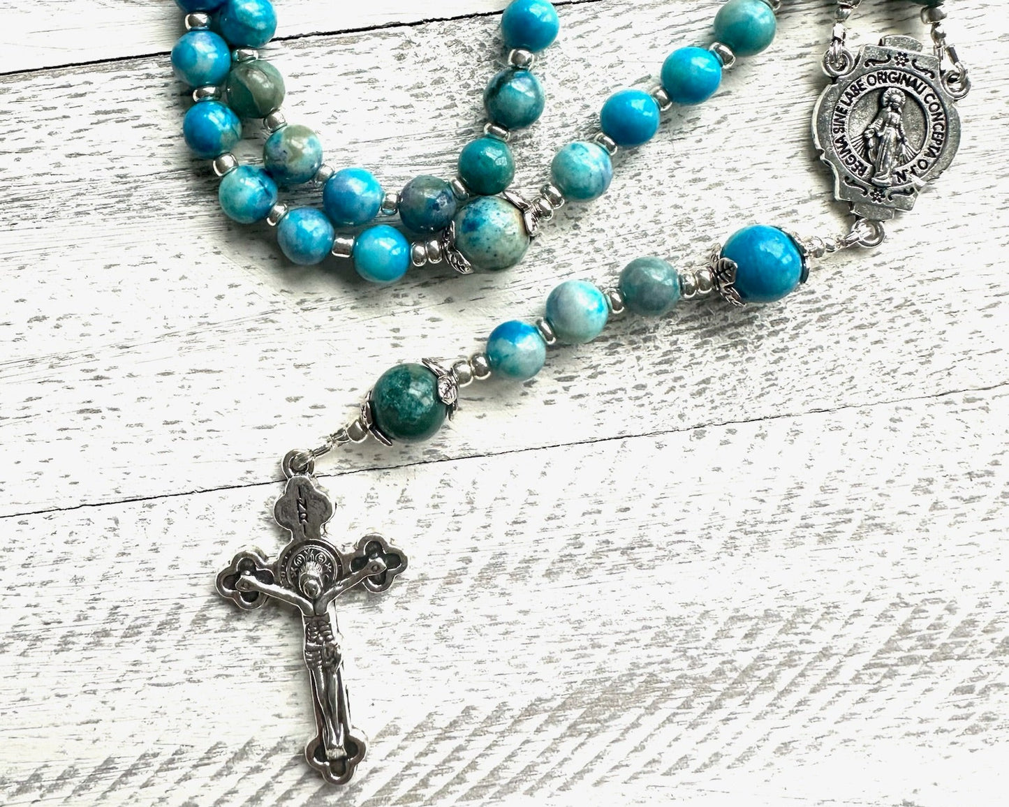 Handmade blue-green apatite rosary with silver findings, Miraculous Medal centerpiece, and silver crucifix; features calming oceanic gemstone tones.