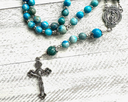 Handmade blue-green apatite rosary with silver findings, Miraculous Medal centerpiece, and silver crucifix; features calming oceanic gemstone tones.